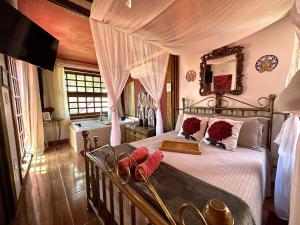 um quarto com uma cama de dossel e almofadas vermelhas em Divina Cabana - Lago Corumbá IV - Alexânia em Alexânia