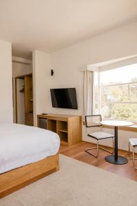 a bedroom with a bed and a desk and a tv at La Posada del Puente in Arequipa