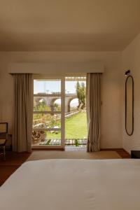 um quarto com uma cama e vista para uma ponte em La Posada del Puente em Arequipa