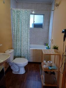 uma casa de banho com um WC, uma banheira e um lavatório. em Casa Celeste em Punta Arenas