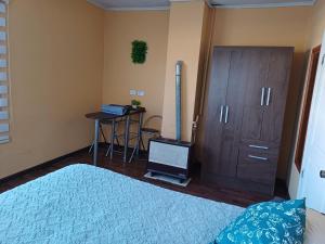 um quarto com uma cama, um armário e uma mesa em Casa Celeste em Punta Arenas