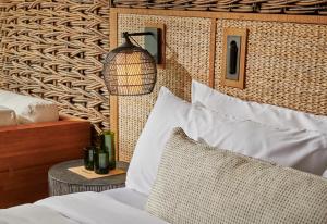 a bedroom with a bed and a lamp on a wall at 1 Hotel Hanalei Bay in Princeville