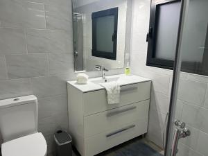 Un baño con lavabo, inodoro y espejo. en Santa Maria , Azores, en Vila do Porto 16 fotos más