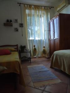 um quarto com 2 camas e uma janela em A casa di Peppino Villa Greco em Tindari