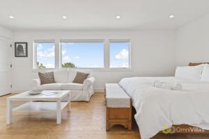 a white bedroom with a bed and a couch at Stunning Views by the Bay 2BR in Brisbane