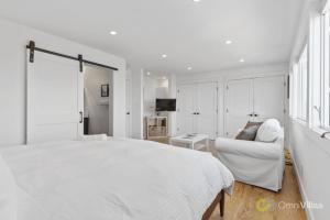 - une chambre blanche avec un lit blanc et un canapé dans l'établissement Stunning Views by the Bay 2BR, à Brisbane