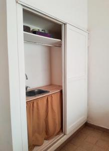 pequeña cocina con fregadero y armario en Alojamiento céntrico, en Puerto Madryn