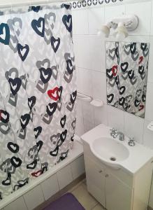 baño con cortina de ducha con corazones en Alojamiento céntrico en Puerto Madryn