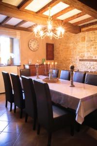 une salle à manger avec une table, des chaises et une horloge dans l'établissement Gîte Le Bol d'Air, à Puilly-et-Charbeaux