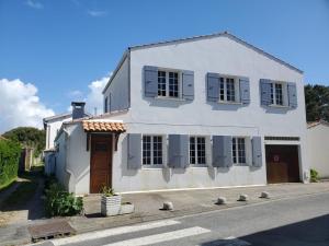 una casa bianca con persiane blu su una strada di Maison Saint-Georges-d'Oléron, 5 pièces, 8 personnes - FR-1-778-19 a Saint-Georges-d'Oléron