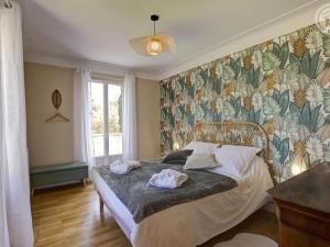 1 dormitorio con 1 cama y papel pintado con motivos florales en Gîte Montbrison, 5 pièces, 9 personnes - FR-1-496-309, en Montbrison