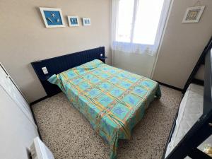 niewielka sypialnia z łóżkiem z kolorową kołdrą w obiekcie Maison Valras-Plage, 4 pièces, 6 personnes - FR-1-781-37 w mieście Valras-Plage