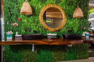 una pared verde con dos lavabos y un espejo en Ocho Artisan Bungalows, en Tamarindo