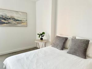 um quarto com uma cama branca e uma planta sobre uma mesa em Luxury Loft Miami Downtown Brickell em Miami