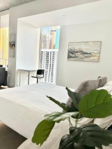 um quarto com uma grande cama branca e uma planta em Luxury Loft Miami Downtown Brickell em Miami