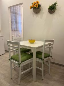 una mesa blanca con dos sillas y un tazón en ella en "Il Gelso" in Villa G reco, en Tindari