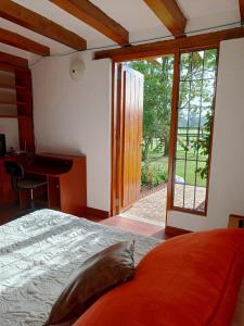 a bedroom with a bed and a sliding glass door at La Isabela Estancia Ecuestre in Tabio