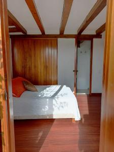 1 dormitorio con 1 cama y suelo de madera en La Isabela Estancia Ecuestre, en Tabio