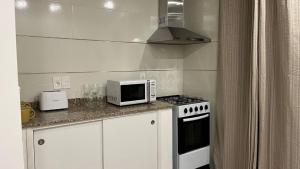 a kitchen with a stove and a microwave on a counter at Relax X in Paysandú