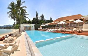 a pool with chairs and umbrellas at a resort at Chi Samui Resort in Bophut