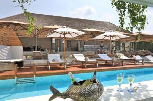 a swimming pool with chairs and umbrellas at Chi Samui Resort in Bophut