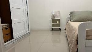 a white bedroom with a bed and a window at Relax X in Paysandú