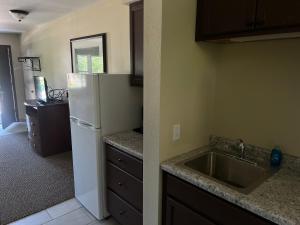 a kitchen with a sink and a white refrigerator at All Star Inn & Suites in Wisconsin Dells