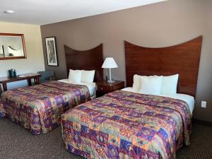 Postel nebo postele na pokoji v ubytování All Star Inn & Suites