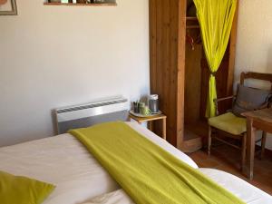 a bedroom with a bed with a green blanket on it at Charmant logement avec piscine et table d'hôtes, proche de Solesmes et de l'abbaye. - FR-1-410-407 in Solesmes +27 photos