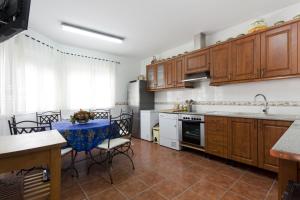 eine Küche mit Holzschränken und einem Tisch mit Stühlen in der Unterkunft Tiara Vacaciones in Nava de la Asunción