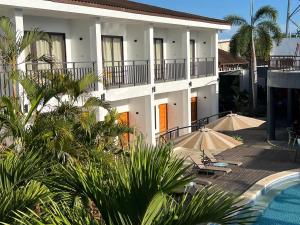 un edificio con 2 sombrillas y una piscina en Holabay Resort, en Panglao