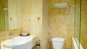 a bathroom with a sink and a toilet and a shower at Lorin Dwangsa Solo Hotel in Solo