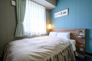 Postel nebo postele na pokoji v ubytování Hotel Econo Kameyama