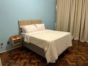 ミゲウ・ペレイラにあるApê no Centro de Miguel Pereiraのベッドルーム1室(白い掛け布団付きのベッド1台付)