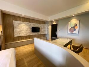 Habitación de hotel con mesa y TV en Boss Mansion en Bangkok