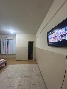 Habitación con TV de pantalla plana en la pared en Hotel Centro en Corumbá