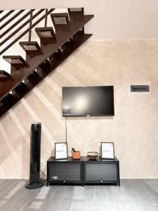 a living room with a television and a table with two pictures at 2BR Home in Davao in Davao City