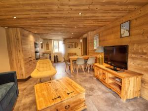 ein Wohnzimmer mit Fernseher und Tisch in der Unterkunft Appartement rénové au cœur de Morillon pour 6 pers. - FR-1-642-89 in Morillon