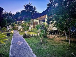 a house with a pathway in front of it at D mas huts lembongan in Nusa Lembongan