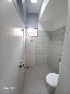 uma pequena casa de banho com um WC e uma janela em ADA Homestay em Borobudur