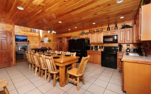 eine Küche mit einem Tisch und Stühlen sowie einem schwarzen Kühlschrank in der Unterkunft Jennies Cove in Pigeon Forge