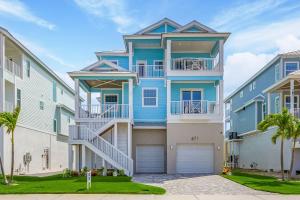 un edificio de apartamentos azul con garaje en 671 Estero Blvd "Ocean Pearl" home, en Fort Myers Beach
