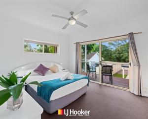 a bedroom with a bed and a sliding glass door at The Moorings in Iluka