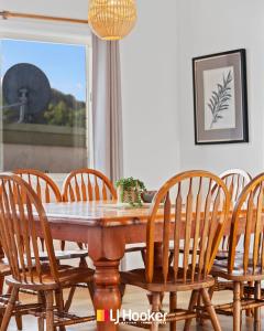 a dining room table with wooden chairs around it at The Moorings in Iluka