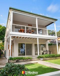 a house with a balcony with chairs on it at The Moorings in Iluka