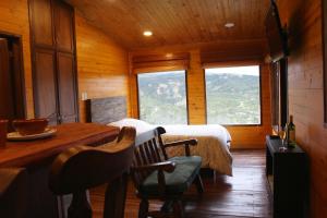 una camera con letto e tavolo in una cabina di Eco Chalet El Encanto La Calera a La Calera