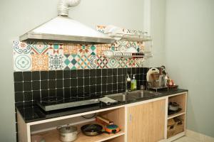 a kitchen with a sink and a tile wall at VietHouse Homestay Ha Long in Ha Long +134 photos