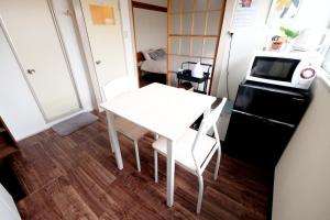 uma pequena cozinha com uma mesa branca e um micro-ondas em Daiichi Mitsumi Corporation - Vacation STAY 15355 em Musashino