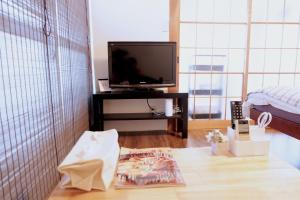 sala de estar con mesa y TV en Daiichi Mitsumi Corporation - Vacation STAY 15355, en Musashino