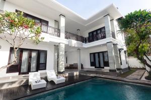 eine Villa mit Swimmingpool und ein Haus in der Unterkunft Maja Villa Batubelig by Pramana Villas in Canggu